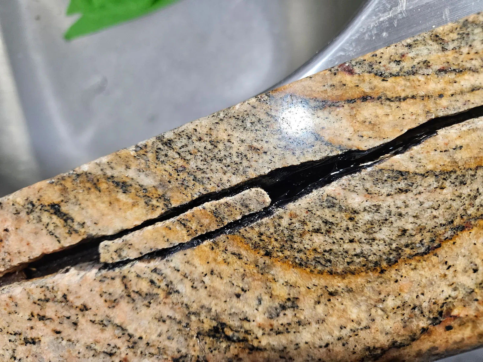 Close-up of epoxy filling in granite crack during structural countertop repair in Craig Ranch
