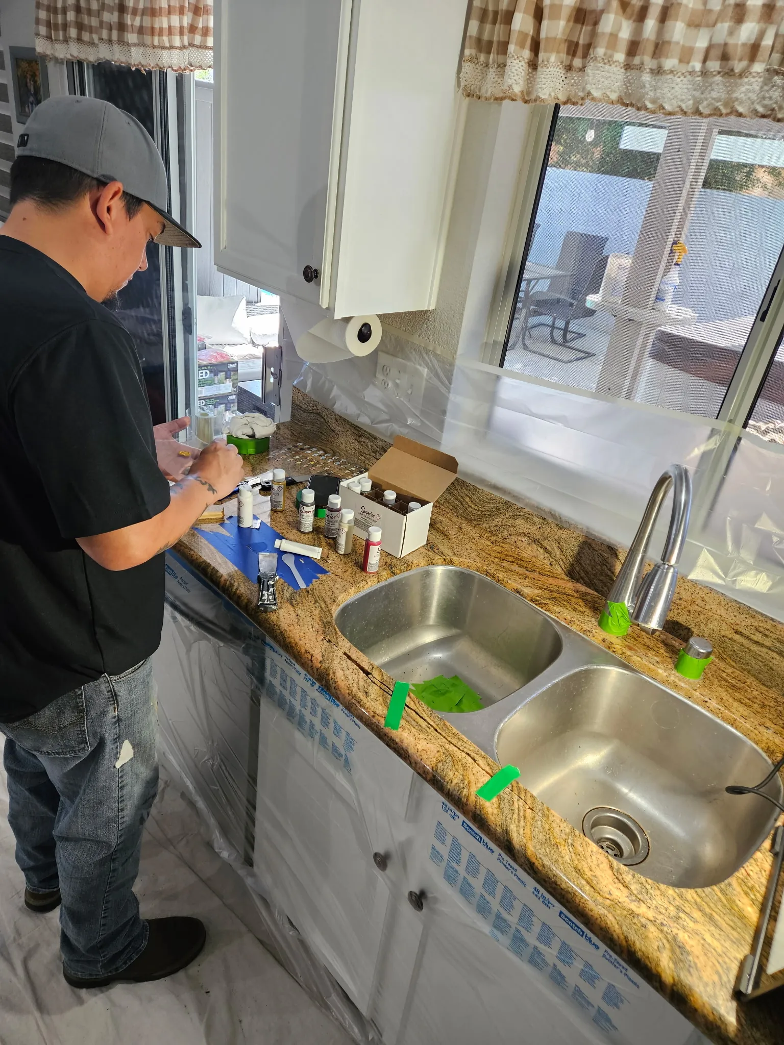 Stone repair technician color-matching pigments and epoxy compounds for granite countertop restoration in Las Vegas