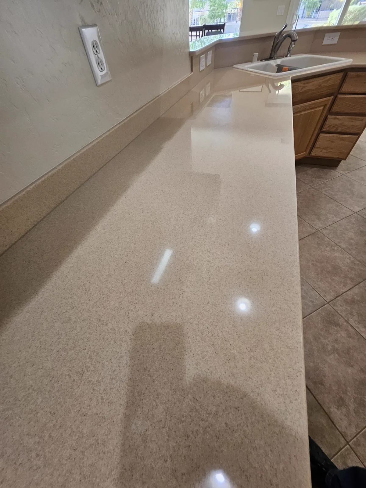 Long finished countertop surface leading toward a white kitchen sink