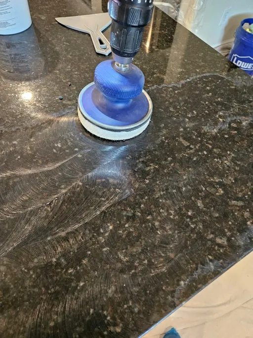Diamond polishing dark granite countertop during restoration