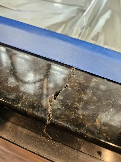 Dark granite countertop edge crack before repair in Henderson