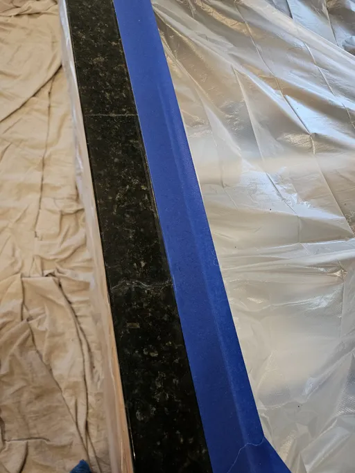 Dark granite countertop masked before crack repair in Henderson