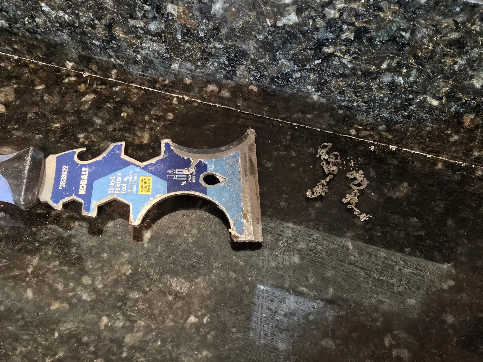 Old sealant being removed from dark granite before resealing