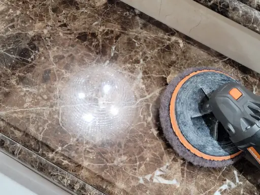 Dark brown Emperador marble surface being polished