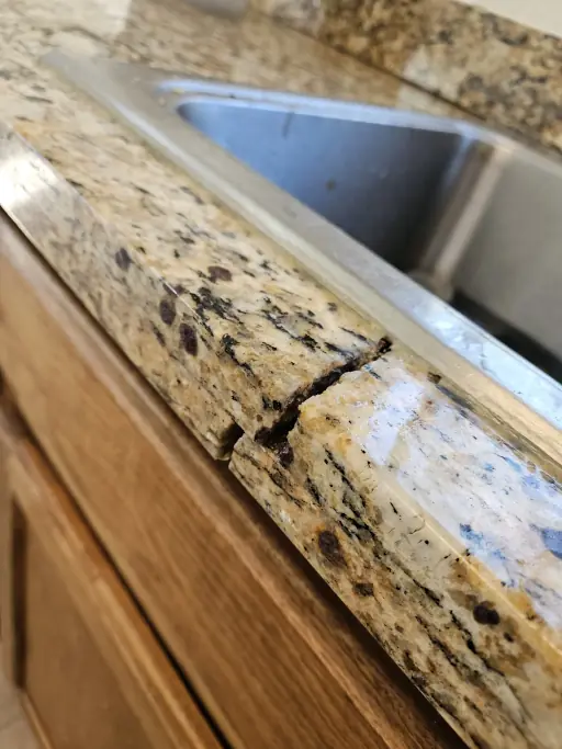 Crack through the narrow granite strip in front of an undermount sink