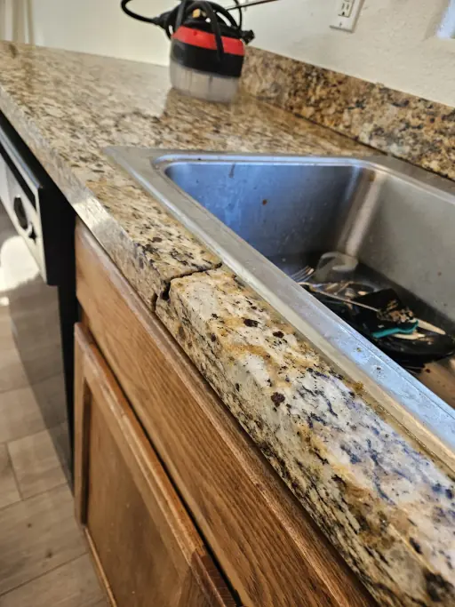 Cracked granite sink edge before repair and the finished kitchen countertop after (before)