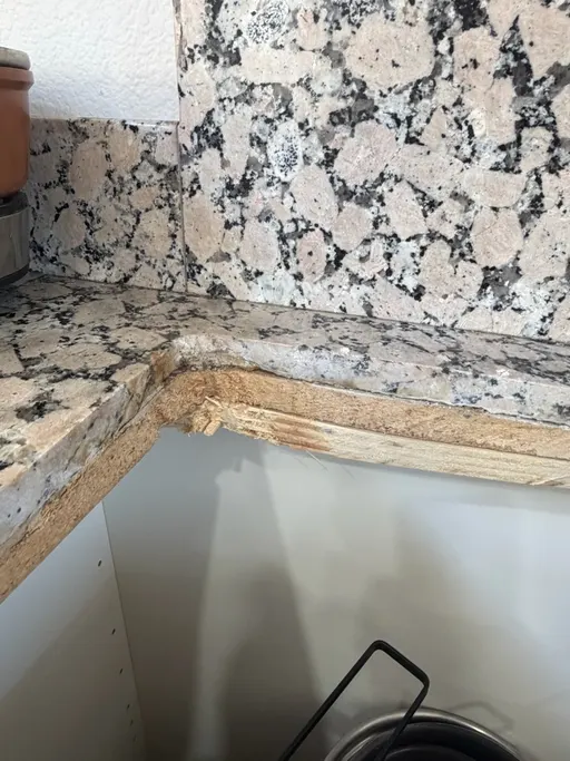 Granite countertop edge split through to the substrate at an inside corner