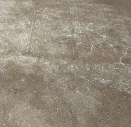 Dull etch marks scattered across a honed stone countertop
