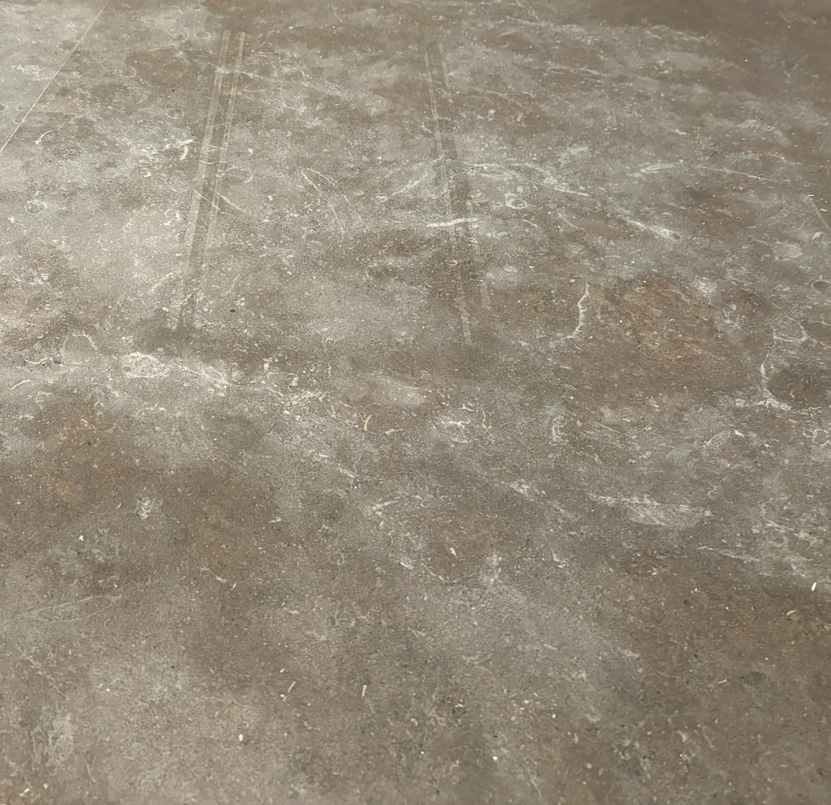 Scattered etch marks across a honed stone countertop