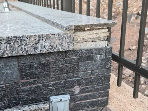 Outdoor granite countertop broken at the end, exposing the layered base under the slab