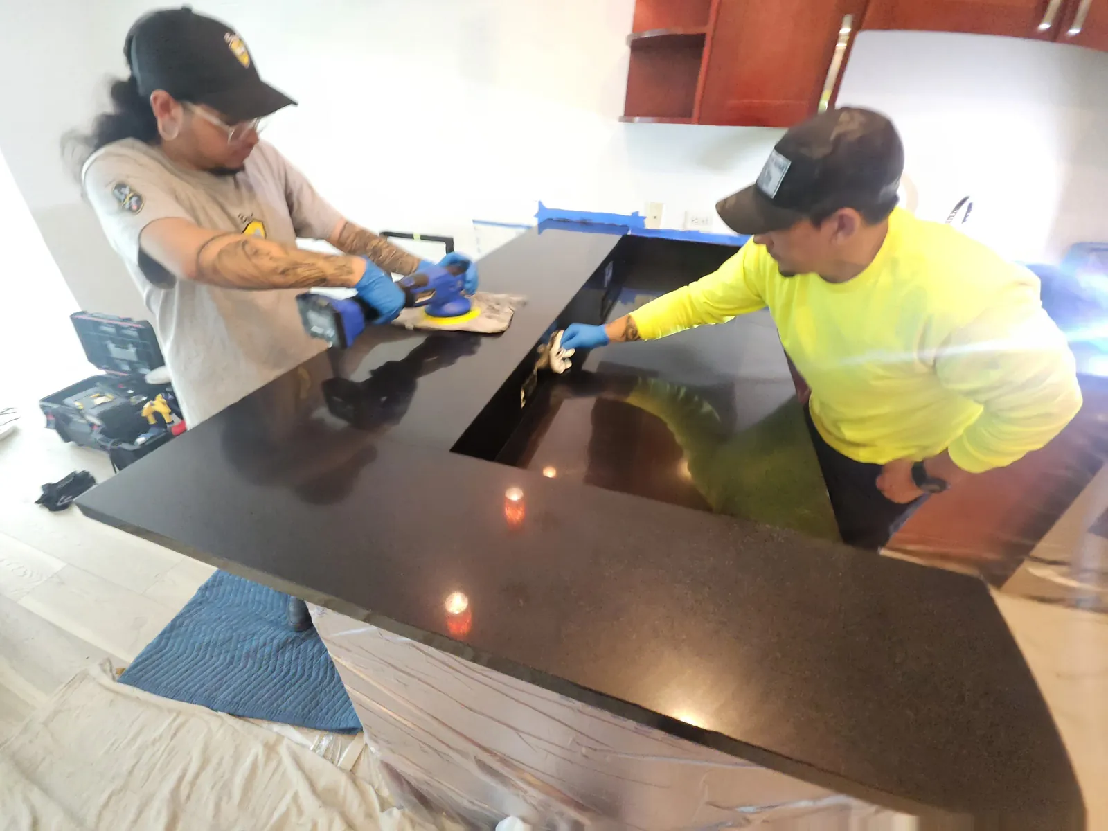 Technicians polishing a black granite countertop near Panorama Towers