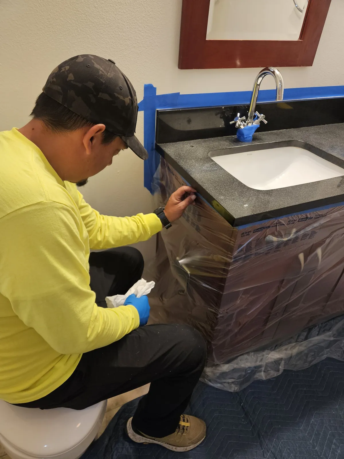 Vanity cabinet masked and protected during stone repair near Panorama Towers