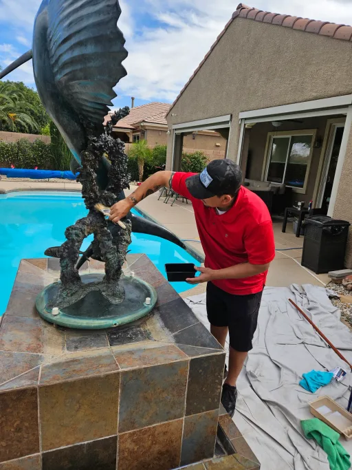 Technician working down low during detailed sculpture cleaning