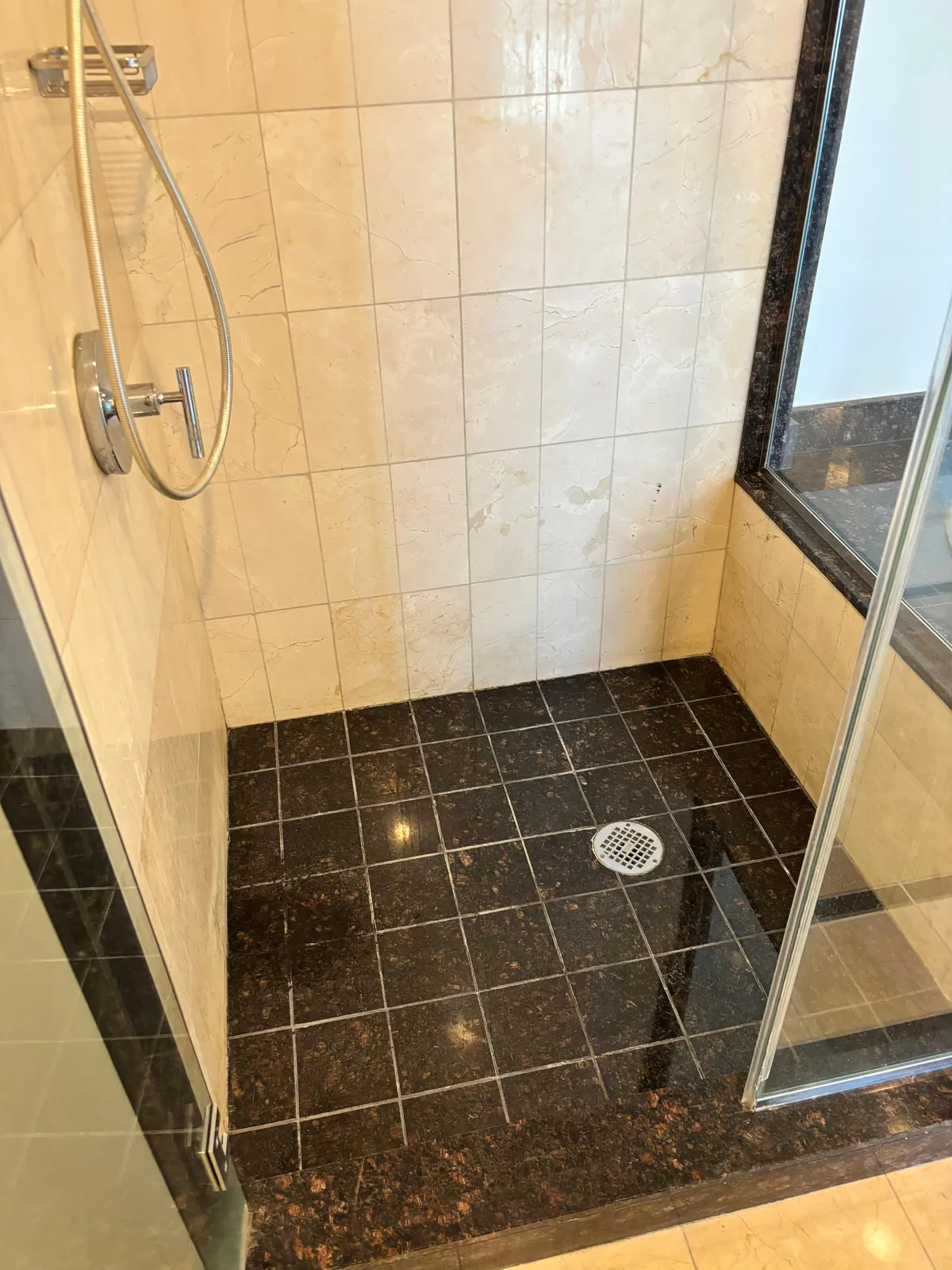 Restored natural stone shower with clean polished tile walls and floor