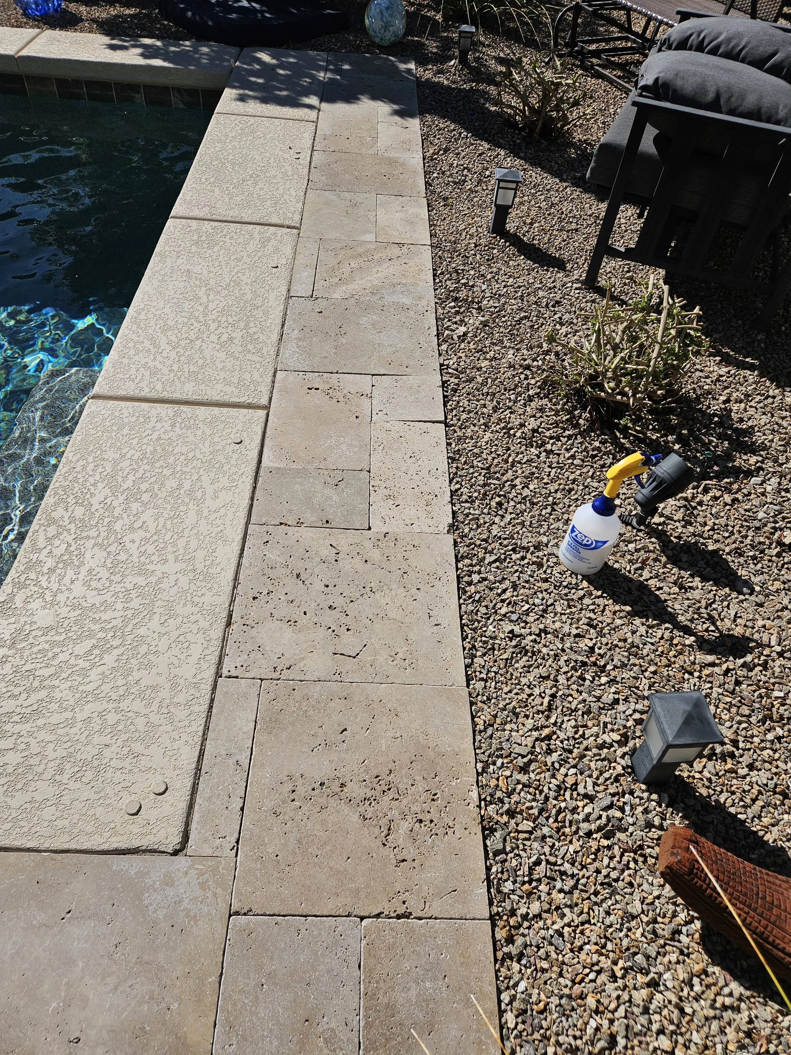 Calcium scale buildup on travertine pool coping before cleaning in Las Vegas