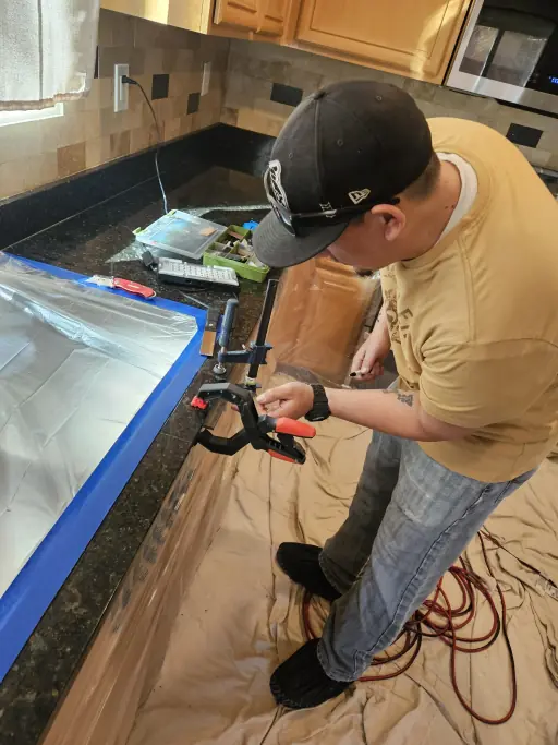 Technician clamping black marble crack repair in Henderson