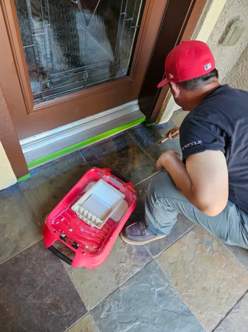 Detail sealing work on entry pavers near a doorway