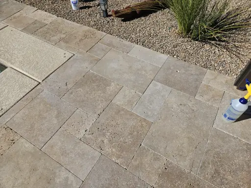 Unsealed travertine pool deck showing wear in Henderson