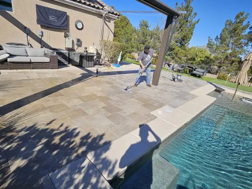 Technician applying penetrating sealer to travertine pool deck