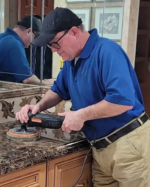 Robert Falzone, owner of Expert Stone Repair, polishing a marble vanity